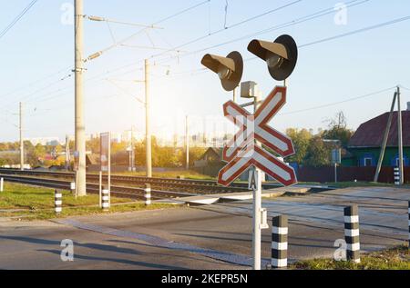 Sicurezza stradale. Semaforo e cartello all'incrocio ferroviario. Foto Stock