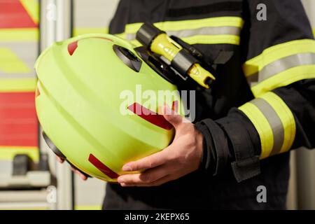 Immagine ravvicinata del casco di un pompiere. Vigile del fuoco con un casco giallo Foto Stock