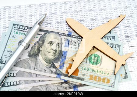 Concetto di business e finanza. Sul tavolo ci sono relazioni, dollari e un modello di legno di un aereo. Foto Stock