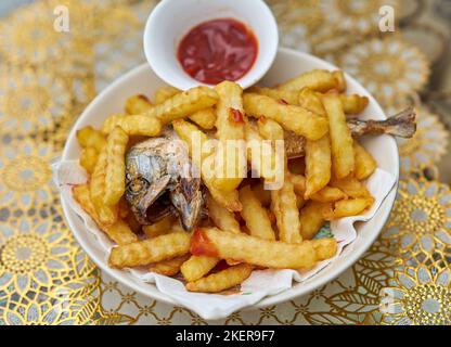 Un piatto di pesce e patatine fritte con ketchup di pomodoro. Foto Stock