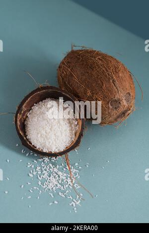 Cocco intero con scaglie di cocco su sfondo blu Foto Stock