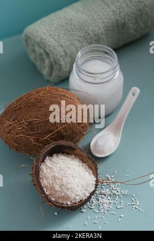 Composizione con olio di cocco naturale organico crema corpo cosmetica su sfondo di colore blu chiaro. Bellezza naturale e concetto di cura del corpo Foto Stock