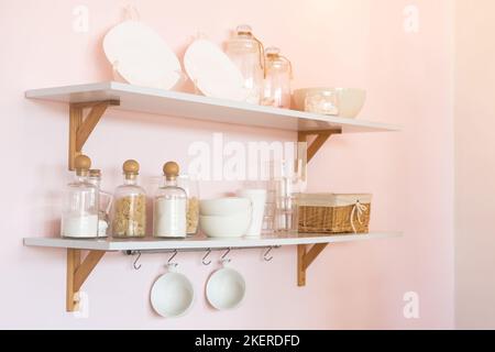 Ripiano da cucina con cereali e pasta in vasetti di vetro. Organizzazione. Scaffale con piatti Foto Stock