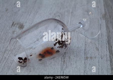 il vino rosso sedimenta in un bicchiere vuoto Foto Stock