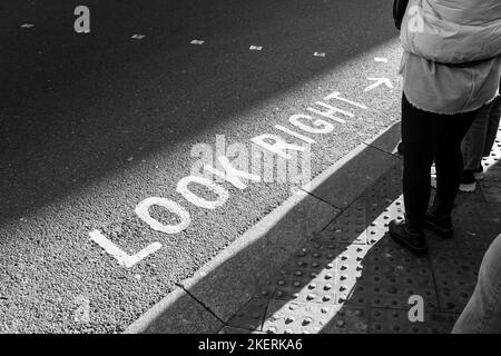 L'iconica segnaletica stradale dipinta a destra per i pedoni a Londra. Concetto: Attraversare la strada, sicurezza stradale, pedoni in attesa, visitare Londra Foto Stock