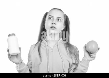 teen girl scegliere tra frutta d'arancia e pillola di vitamina in vaso bottiglia isolato su bianco, additivi alimentari. Foto Stock