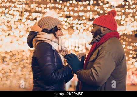 Foto di bella moglie dolce marito indossare abiti stagione invernale godendo il miracolo di Natale fuori città strada Foto Stock