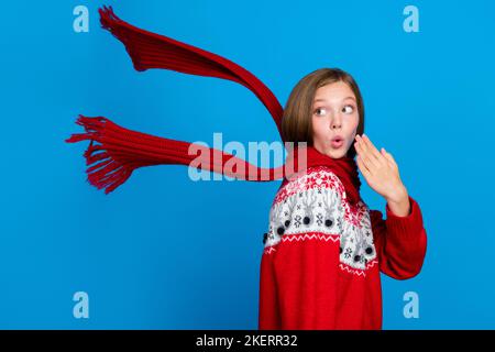 Foto di Dreamy impressionato scuola ragazza indossare rosso xmas ornamento maglione guardando indietro vuoto spazio isolato di colore blu sfondo Foto Stock