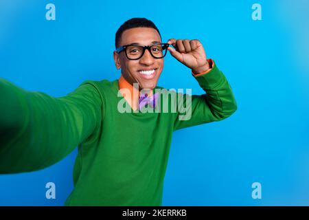 Selfie closeup cadre del giovane imprenditore popolare uomo d'affari toccare le sue specifiche overjoyed ricco macho isolato su sfondo di colore blu Foto Stock