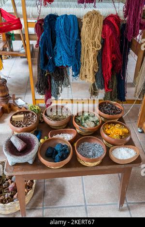 Ciotole contenenti le fonti per i coloranti naturali utilizzati nei migliori tappeti di Teotitlan del Valle, Oaxaca, Messico. Dietro sono le matasse di filato dopo dyi Foto Stock