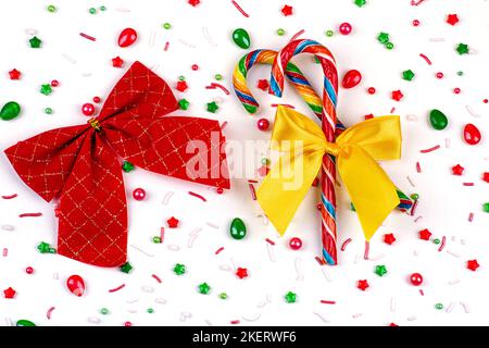 Sfondo natalizio di caramelle colorate, caramelle e archi, su sfondo bianco, primo piano Foto Stock