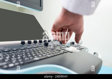 vista parziale del medico che regola la macchina a ultrasuoni in ospedale,immagine stock Foto Stock