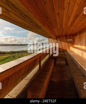 Ammirando le paludi salate e la campagna del Dorset dall'interno del Middlebere nascondiglio a RSPB Arne, Wareham, Dorset. Foto Stock