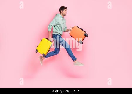 Lunghezza intera profilo foto laterale di attraente divertente ragazzo fretta aeroporto registrazione spostare guardare vuoto spazio isolato su sfondo di colore rosa Foto Stock