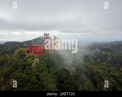 Vista aerea del parco e del Palazzo Nazionale di pena a Sintra, Portogallo durante una giornata di nebbia. UNESCO. Visite storiche. Visite turistiche. Fiaba. Foto Stock