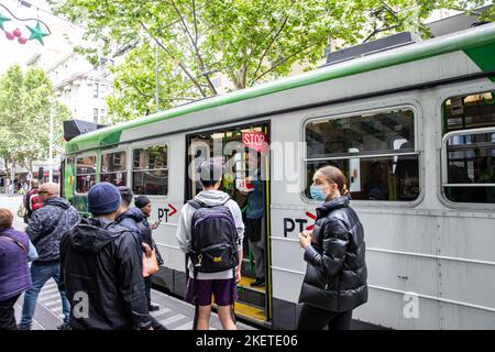 I passeggeri a bordo di un tram di melbourne giovane donna indossa il facemask a causa del covid 19 coronavirus, Melbourne Victoria, Australia Foto Stock