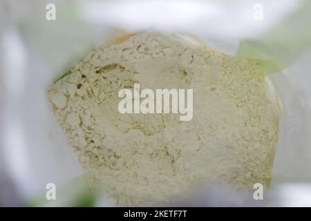 Sacco di carta sfocato, sacco, con farina su sfondo bianco. Aprire il sacchetto di farina. Farina di grano in sacco di tela di arbusto all'interno. Fuori fuoco Foto Stock