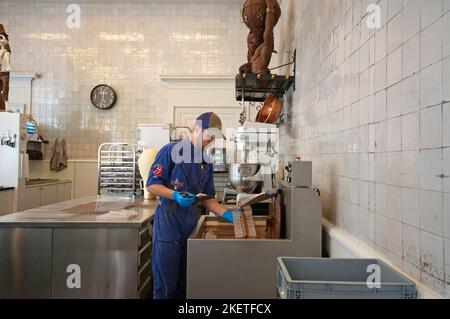 Cioccolatiere nel laboratorio del famoso negozio 'The Chocolate Line', Anversa (Fiandre), Belgio Foto Stock