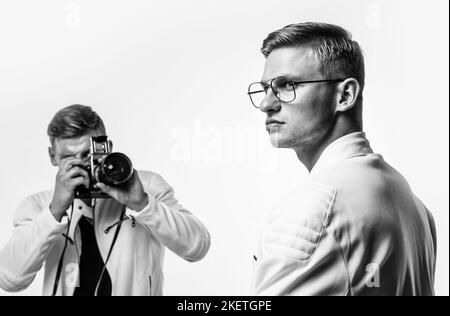 gli uomini gemelli dei fratelli osservano allo stesso modo usano la macchina fotografica vintage, fotografando Foto Stock