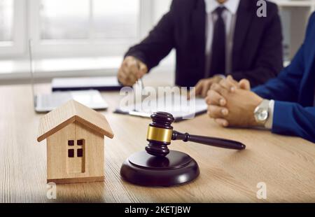 Modello di casa e barrister su tavolo in ufficio avvocato Foto Stock