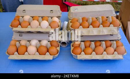 Scatola di uova aperta con uova bianche e marroni. Uova fresche di pollo biologiche in un cartone o in un contenitore per uova. Foto Stock