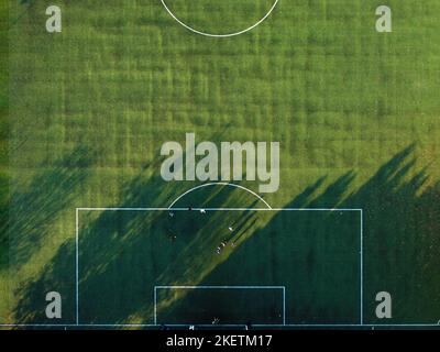 Persone che praticano il calcio su un campo verde Foto Stock