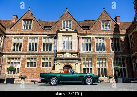 Profilo Vista di un Aston Martin V8 volo Vantage 1988 in verde di fronte a Shaw House, Newbury Foto Stock