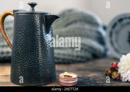 Bella teiera textural su uno sfondo sfocato in una casa accogliente interni. Foto Stock