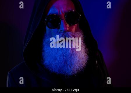 Foto di sicuro bel pensionato uomo vestito nero pullover eyewear cattivo babbo babbo natale costume isolato di colore blu scuro sfondo Foto Stock