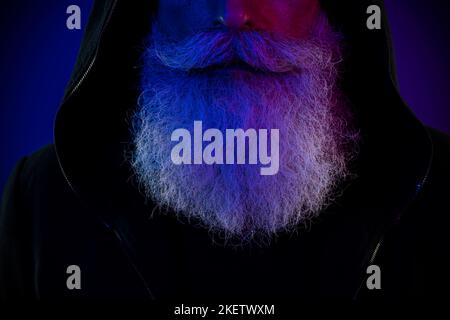 Foto di attraente uomo in pensione vestito nero pullover barba isolato sfondo di colore blu scuro Foto Stock
