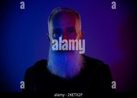 Foto di un elegante pensionato uomo vestito nero pullover che ti guarda isolato sfondo di colore blu scuro Foto Stock