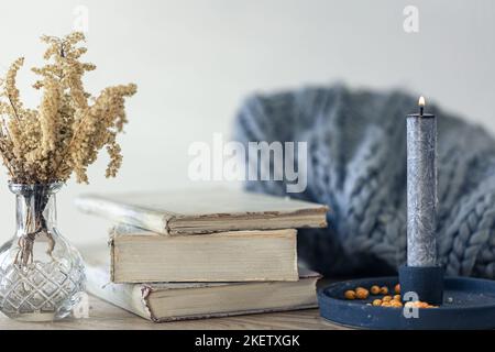 Composizione casalinga accogliente con libri in primo piano sul tavolo. Foto Stock