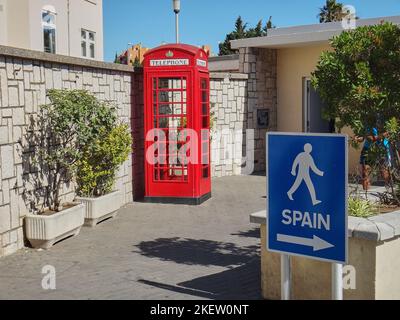 Gibilterra, Regno Unito - 06 08 2014: Cabina telefonica inglese tipica e segno pedonale blu e bianco nel territorio sovrano britannico in Spagna Foto Stock