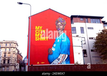 'My City My Shirt' murale donna gallese africana incinta che indossa una maglia da calcio Butetown Cardiff Bay area Galles Regno Unito Gran Bretagna KATHY DEWITT Foto Stock