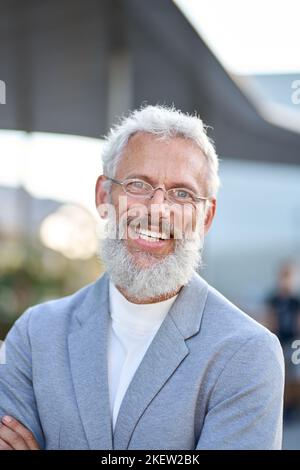 Sorridente uomo d'affari anziano maturo felice all'aperto, ritratto verticale con foto alla testa. Foto Stock