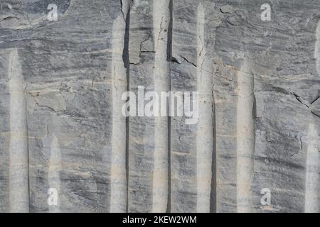 Blocco di marmo con tagli di estrazione cava. Texture di fondo roccia metamorfica. Foto Stock