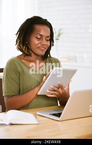 Ritratto di allegro freelancer che lavora su un computer tablet a casa Foto Stock