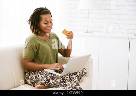 Donna felice usando la carta di credito per fare acquisti online Foto Stock