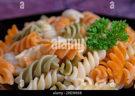Pasta colorata a spirale su un piatto Foto Stock