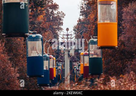 Cabine colorate in autunno foresta con alberi dorati e cielo grigio. Colore graduato Foto Stock