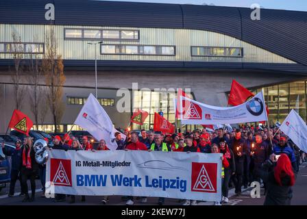 Lipsia, Germania. 14th Nov 2022. I dipendenti BMW lasciano lo stabilimento di Lipsia con bandiere e striscioni per uno sciopero di avvertimento. IG-Metall aveva richiesto lo sciopero di avvertimento durante il terzo round in corso di contrattazione collettiva nell'industria metallurgica ed elettrica. L’Unione sta chiedendo salari e stipendi più alti dell’8 per cento in risposta agli aumenti dei prezzi. Credit: Jan Woitas/dpa/Alamy Live News Foto Stock