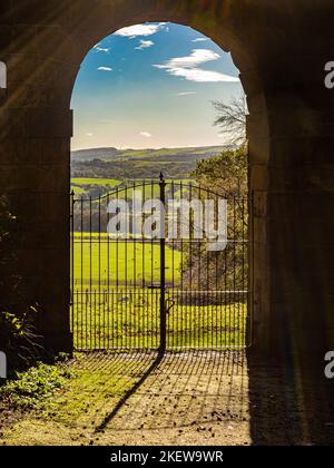 Guardando fuori attraverso uno degli archi dell'Archer's Hill Gate verso il parco dei Giardini del Castello di Wentworth. REGNO UNITO Foto Stock