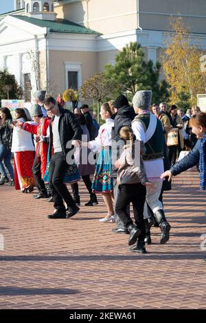 Bendery, Moldavia - 12 novembre 2022: La gente danza la danza moldava. Uomini e donne in costume nazionale ballano la bella chora moldavia alla vigilia Foto Stock