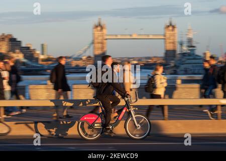 Un uomo che pedalò attraverso il London Bridge durante l'ora di punta, con un trasporto per Londra Santander Cycles noleggio biciclette, comunemente noto come una 'Boris Bike'. Londra Foto Stock