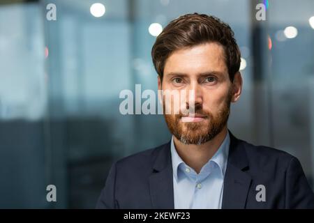 Primo piano ritratto di un imprenditore maturo serio investitore professionale, uomo che guarda la fotocamera con concentrazione, capo manager all'interno dell'ufficio al lavoro. Foto Stock