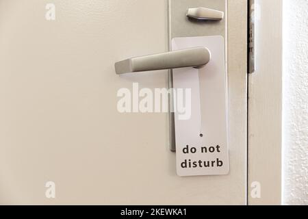 Porta chiusa della camera di albergo con si prega di non disturbare segno.  Hotel porta appendiabiti Tags mockup Foto stock - Alamy