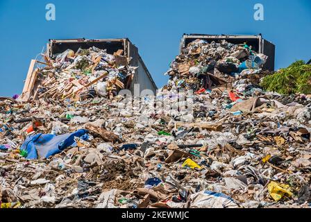 Due semirimorchi riempiti di rifiuti in una discarica attiva. Foto Stock