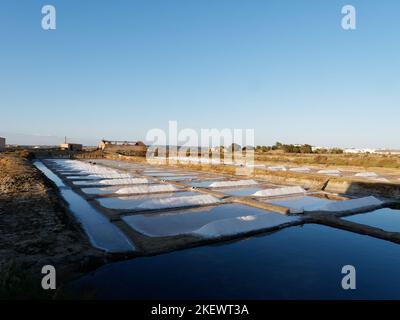 Tramonto colpo cinematografico di campi di sale dopo un'intera giornata di raccolta del sale. Bei colori vibranti. Campi di sale a Castro marim, Portogallo. Estrazione del sale. Foto Stock