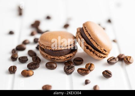 Dolce al macaron. Macaron e chicchi di caffè sul tavolo da cucina. Foto Stock