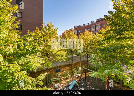 Altalene e scivoli in legno nelle aree comuni di uno sviluppo abitativo urbano Foto Stock